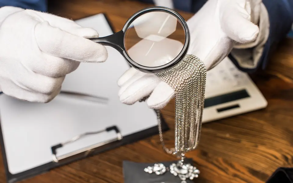 Zoom in a Jeweler's  hands while repairing a silver chain
